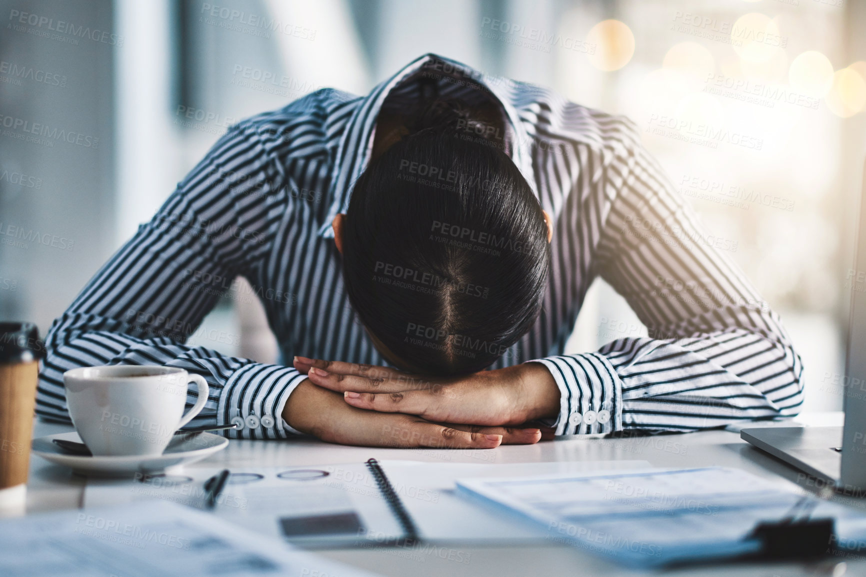 Buy stock photo Shot of a young businesswoman lying with her head down on a desk in an office