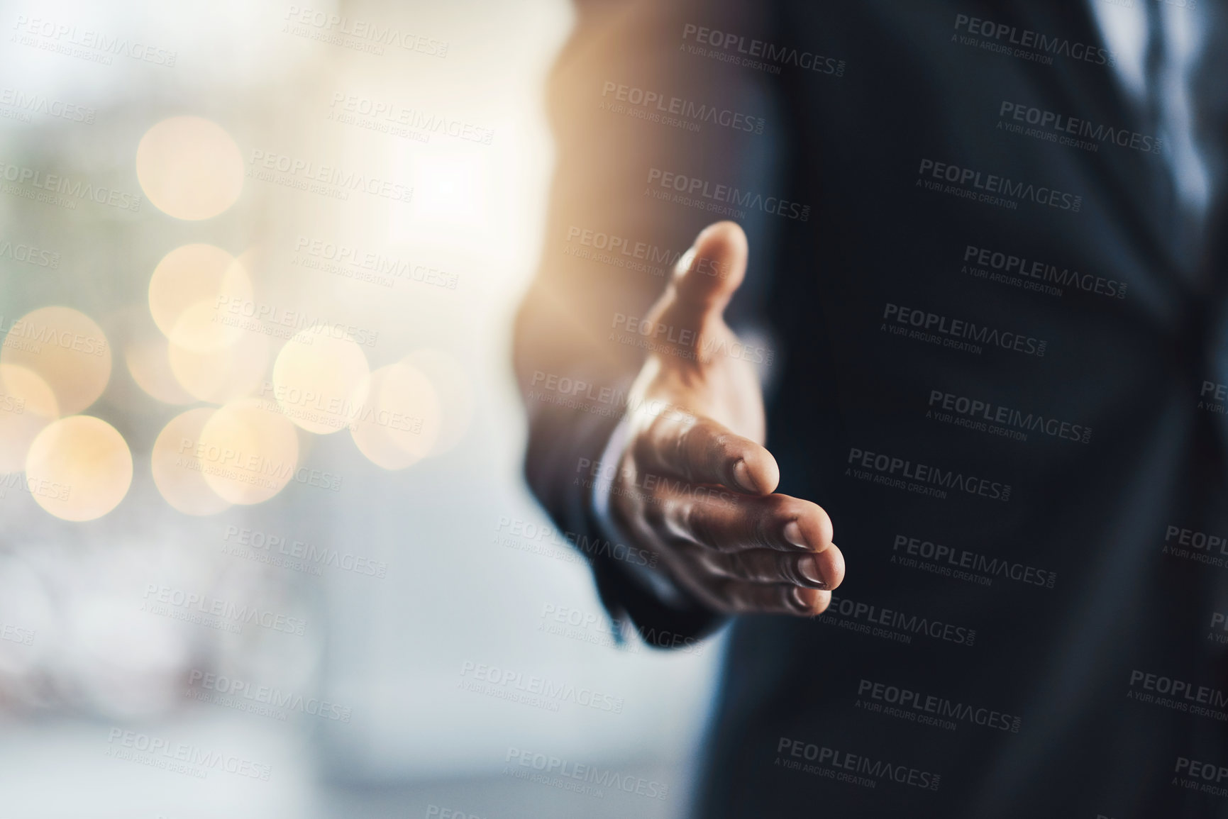 Buy stock photo Cropped shot of an unrecognizable young businessman offering his hand while standing in his modern office