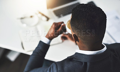 Buy stock photo High angle shot of an unrecognizable young businessman drinking coffee while working in his modern office