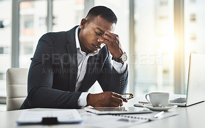 Buy stock photo Cropped shot of a young businessman suffering with a headache while working in his modern office