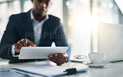 Buy stock photo Cropped shot of a young businessman working on his tablet in a modern office