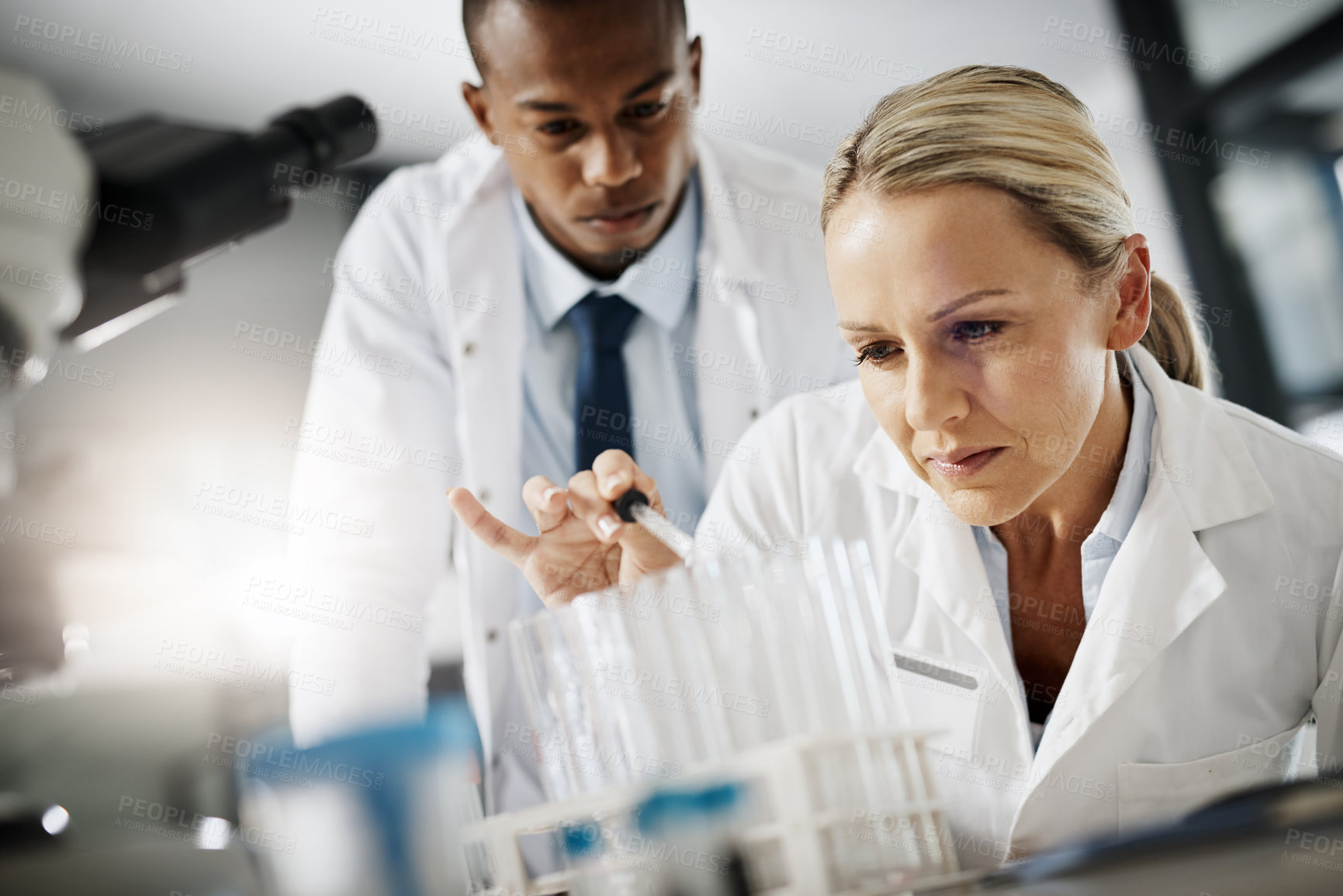 Buy stock photo Cropped shot of two scientists testing a sample while doing research in their lab