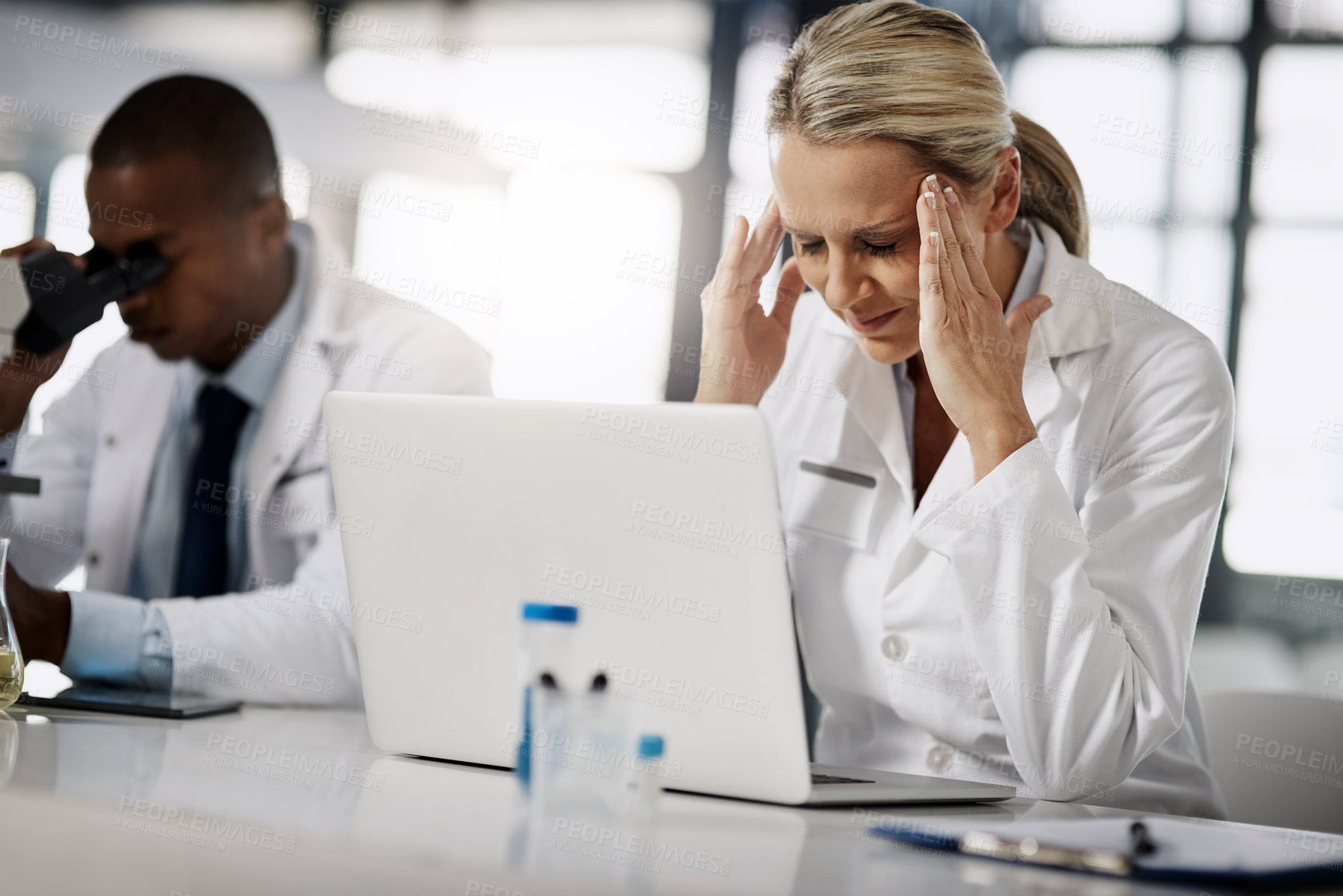 Buy stock photo Cropped shot of a mature female scientist suffering with a headache while working in her research lab