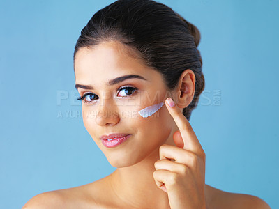 Buy stock photo Happy woman, portrait and beauty cream with skincare for facial treatment on a blue studio background. Female person or model applying cosmetics or anti aging lotion for dermatology or cosmetology