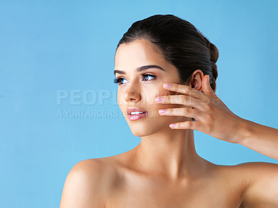 Buy stock photo Studio shot of a beautiful young woman posing against a blue background