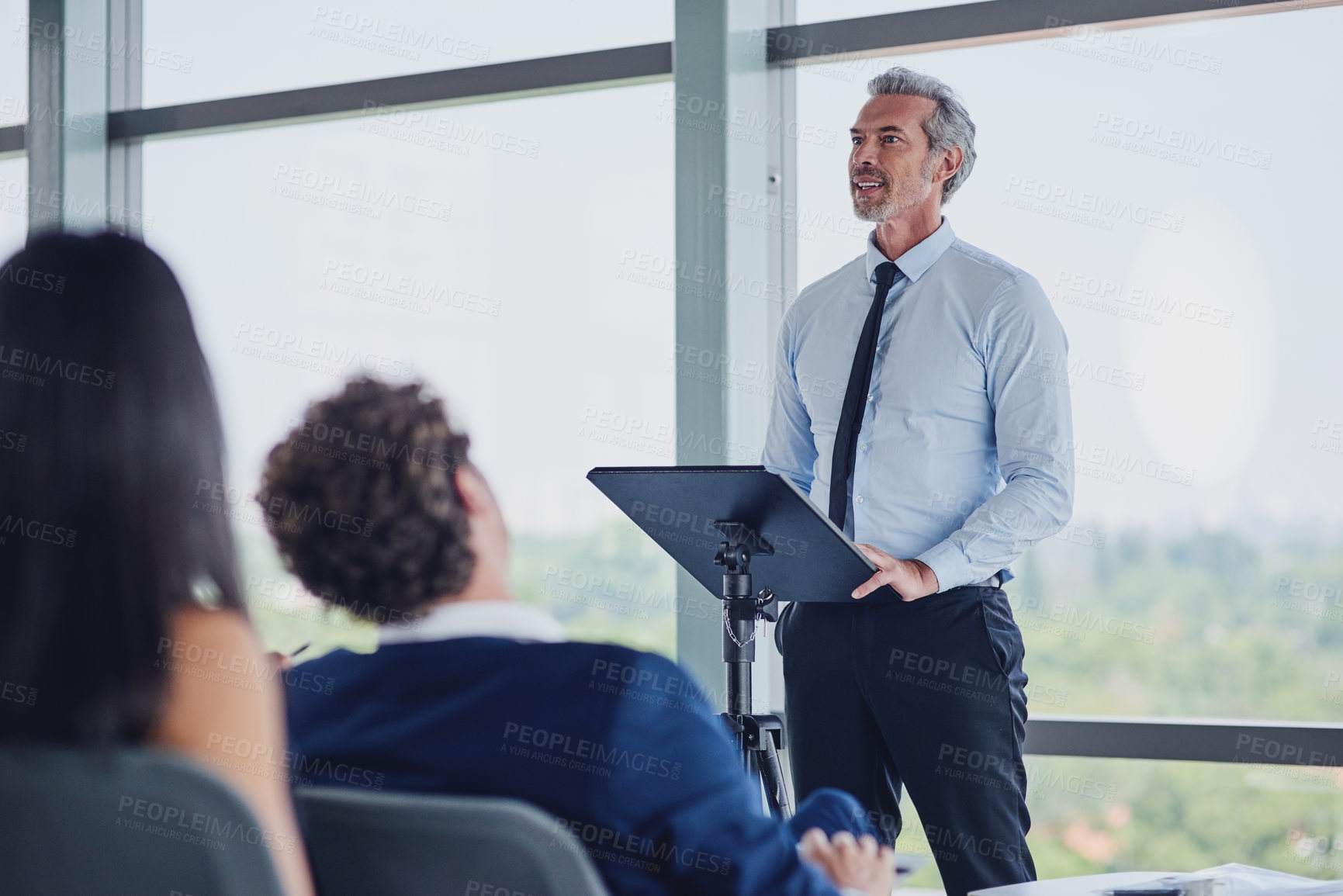 Buy stock photo Low angle shot of a handsome mature male speaker addressing a group of businesspeople during a seminar in the conference room