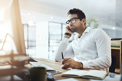 Buy stock photo Shot of a young businessman looking bored while working in an office