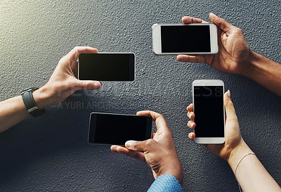 Buy stock photo Shot of unrecognizable people holding smartphones against a grey background