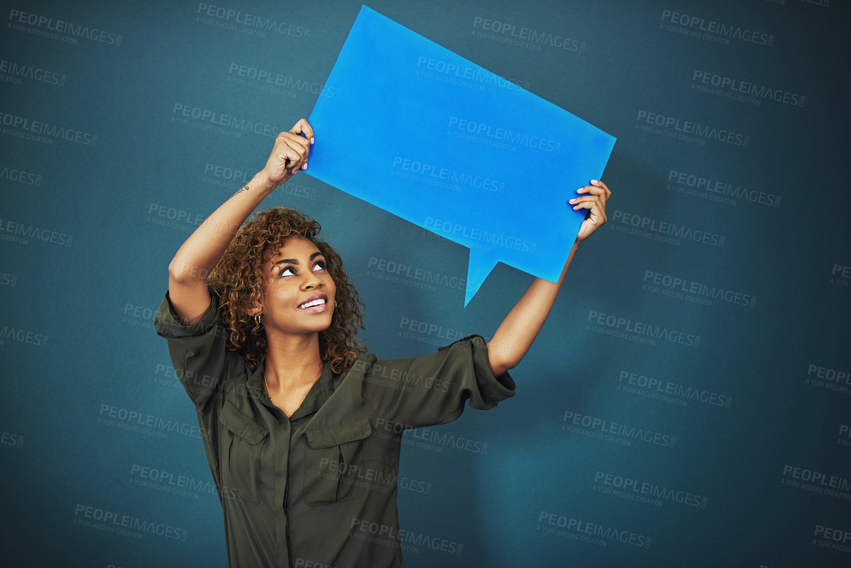 Buy stock photo Studio shot of a woman holding a speech bubble against a blue background