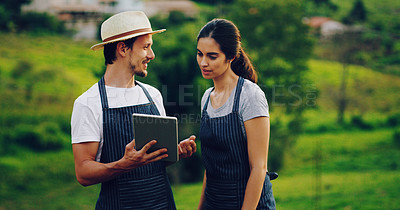 Buy stock photo Shot of a young couple using a digital tablet together while working in a garden