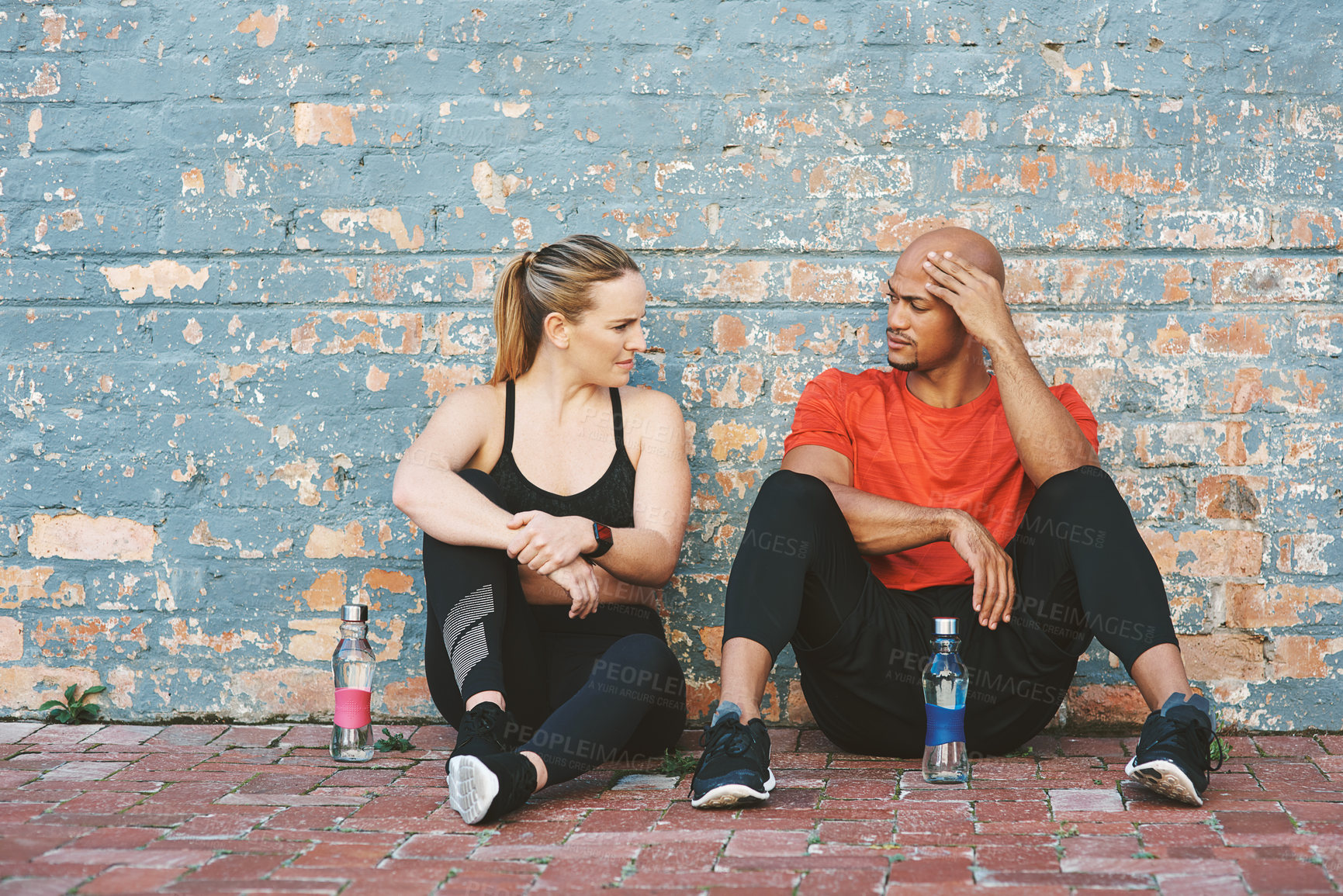 Buy stock photo Brick wall, tired and coach with woman for workout, exercise and water bottle for sport. Partnership, personal trainer and athlete on break or fitness at gym for wellness, training and health