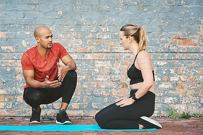 Buy stock photo Discussion, talking and coach with woman for workout, exercise and fitness for sport. Partnership, personal trainer and athlete on break by brick wall at gym for wellness, training and health