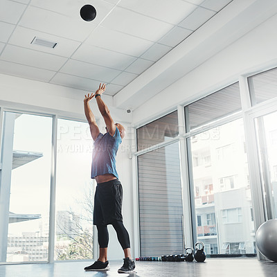 Buy stock photo Shot of a young man working out at the gym