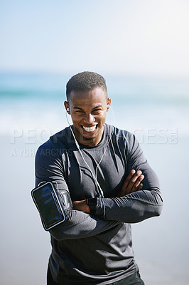 Buy stock photo Portrait of a sporty young man listening to music while exercising outdoors