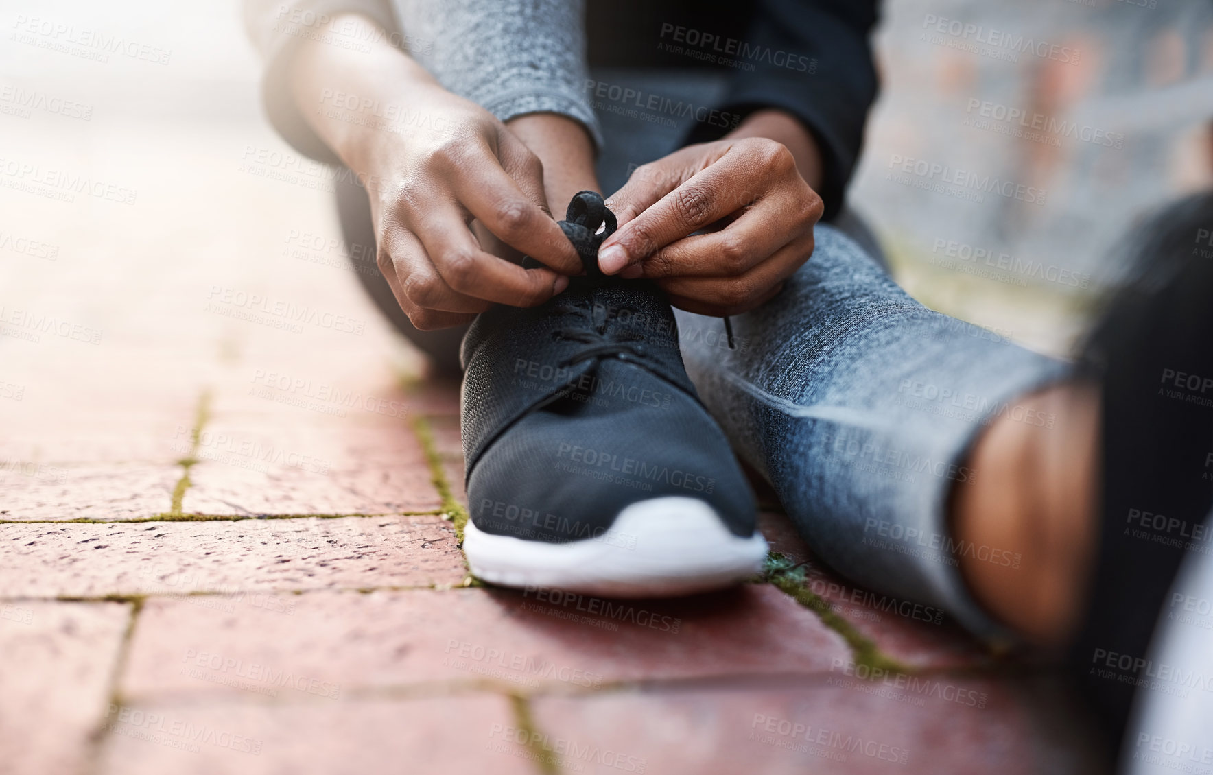 Buy stock photo Cropped shot of a woman tying her shoelaces before a workout session