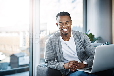 Buy stock photo Portrait of a happy young man using a laptop while relaxing at home