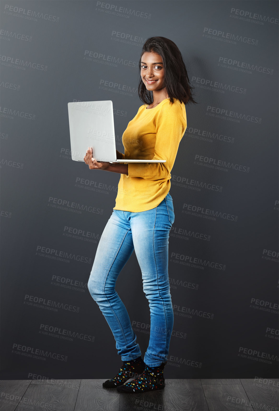 Buy stock photo Portrait, happy indian woman standing with laptop and in wall background. Social media or networking, technology or communication and smiling African female worker with mockup in studio backdrop.