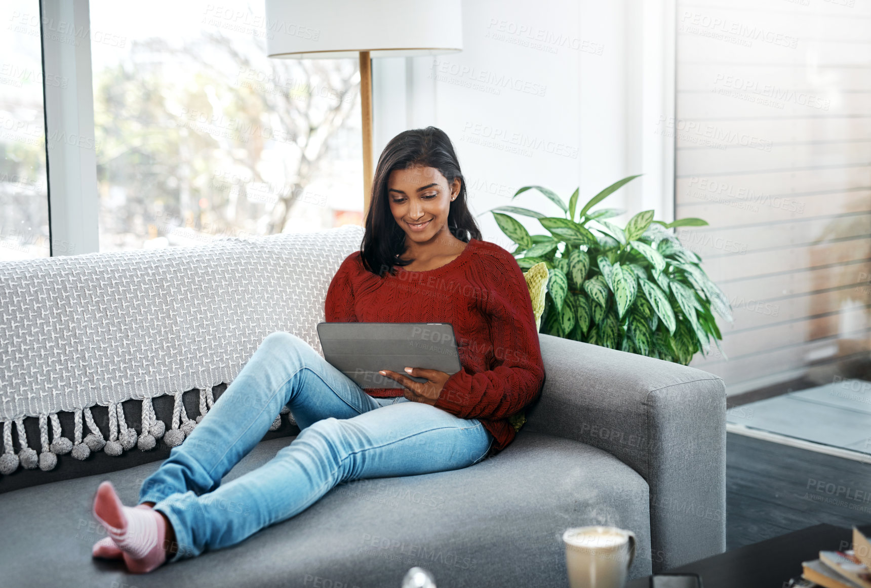 Buy stock photo Relax, home and woman on sofa with tablet for social media, networking or streaming on weekend. Smile, connect and girl on couch with digital app for communication, online chat or search in apartment