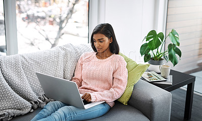 Buy stock photo Woman, laptop and typing on home sofa for student research, streaming or social media. Indian female person on a couch to relax, surfing internet or writing email for communication on website