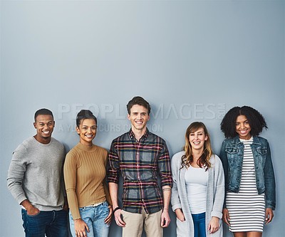 Buy stock photo Studio portrait of a diverse group of young people standing together against a gray background