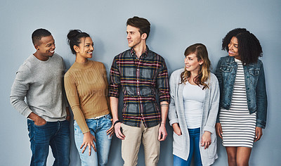 Buy stock photo Studio shot of a diverse group of young people standing together against a gray background