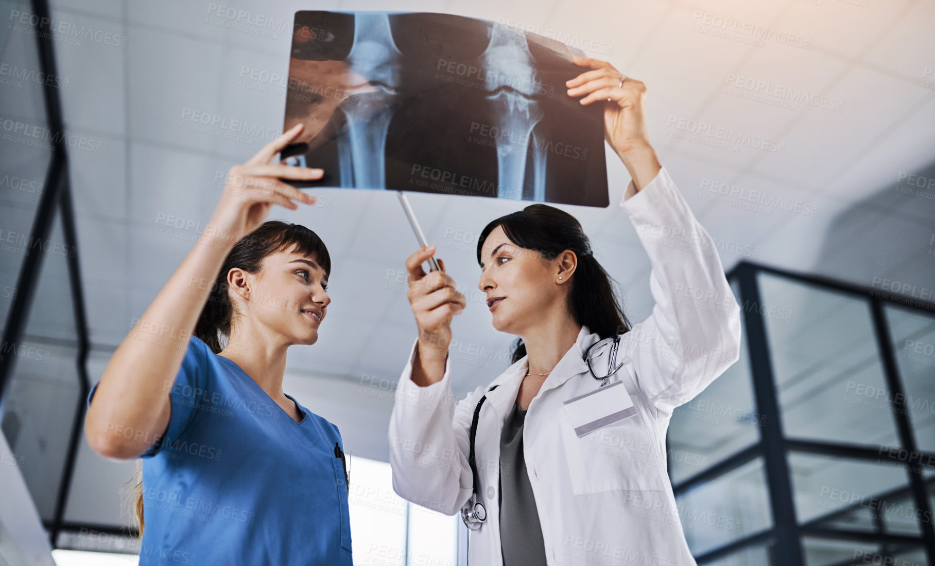 Buy stock photo Shot of two doctors discussing the results of an X-ray in a hospital