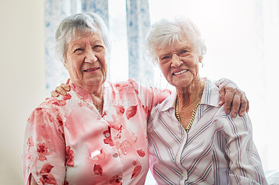Buy stock photo Portrait of two happy elderly women embracing each other at home