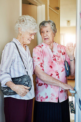 Buy stock photo Shot of two elderly woman closing the door before they leave to go out