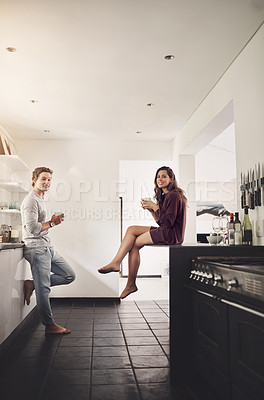 Buy stock photo Shot of a happy young couple enjoying a relaxing cup of coffee together in the kitchen
