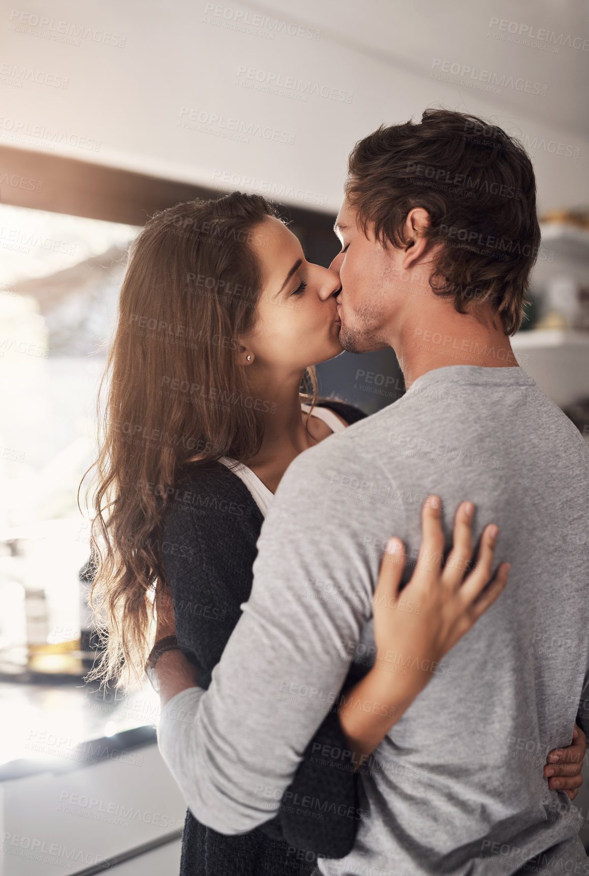 Buy stock photo Young, couple and kissing in home for love, romantic bond and intimacy of special moment together. Man, woman and romance of partners with kiss for happy relationship, passionate affection and care