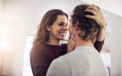 Buy stock photo Shot of an affectionate young couple hugging in the kitchen at home