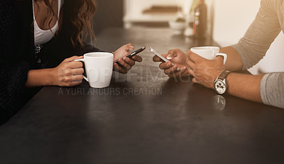 Buy stock photo Cropped shot of a young couple using their mobile phones and having coffee at home