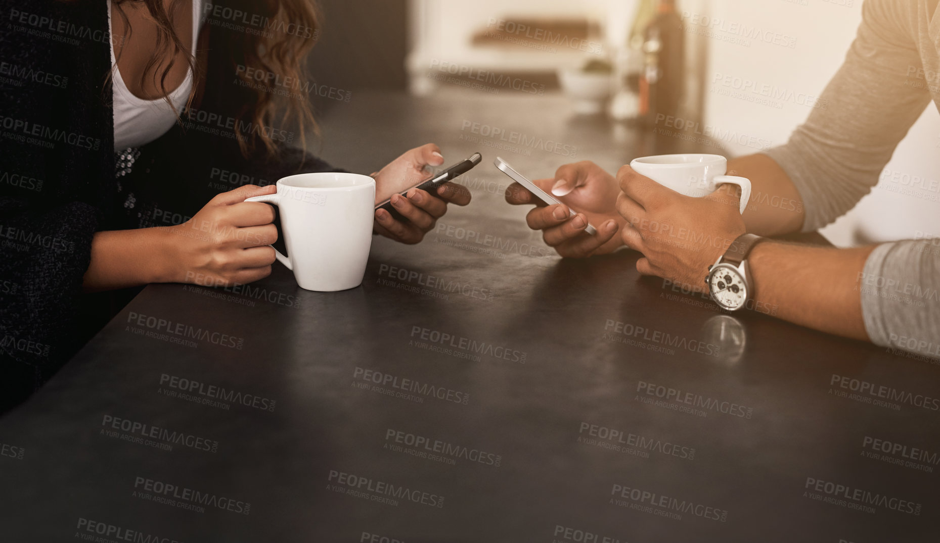 Buy stock photo Cropped shot of a young couple using their mobile phones and having coffee at home
