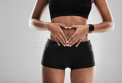 Buy stock photo Shot of an unrecognizable woman making a heart shape with her hands on stomach