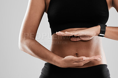 Buy stock photo Cropped shot of an unrecognizable woman holding her hands against her stomach