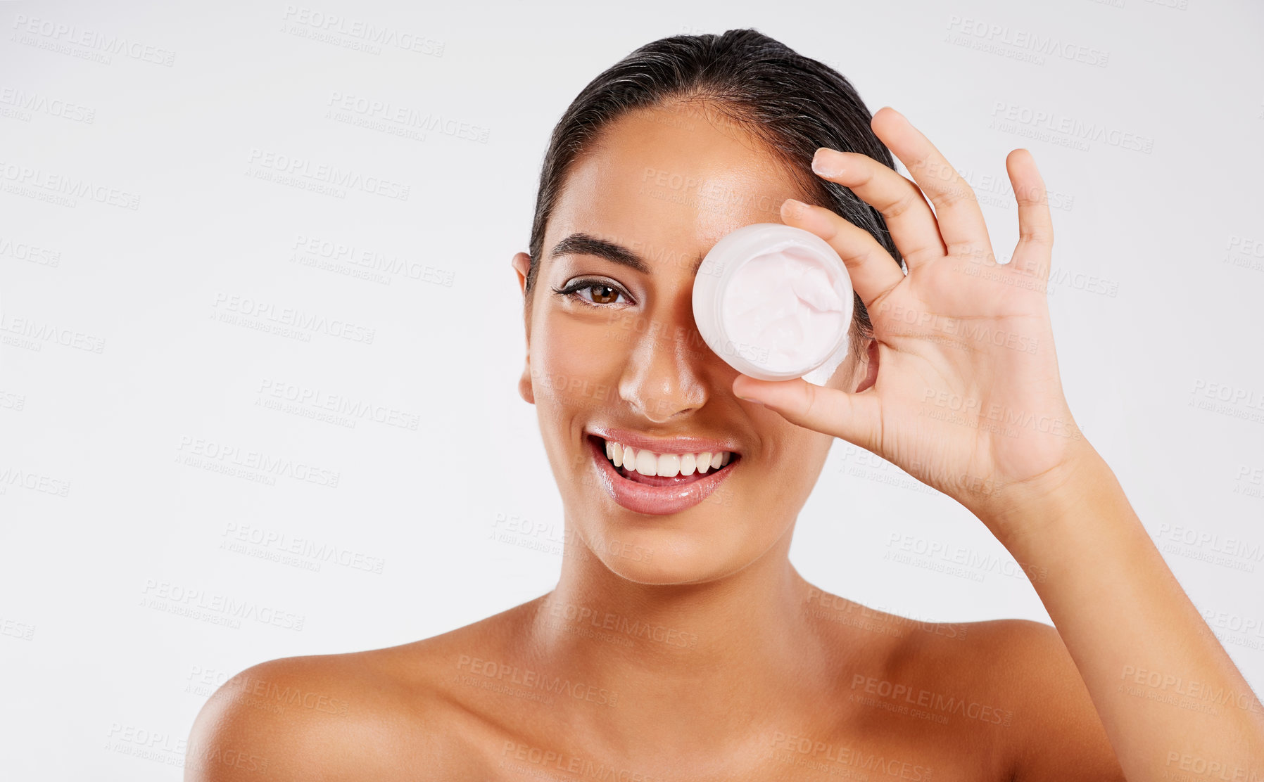 Buy stock photo Studio portrait of a beautiful young woman holding a container of lotion against a gray background