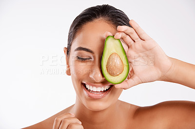 Buy stock photo Studio shot of a beautiful young woman holding half an avocado against a gray background