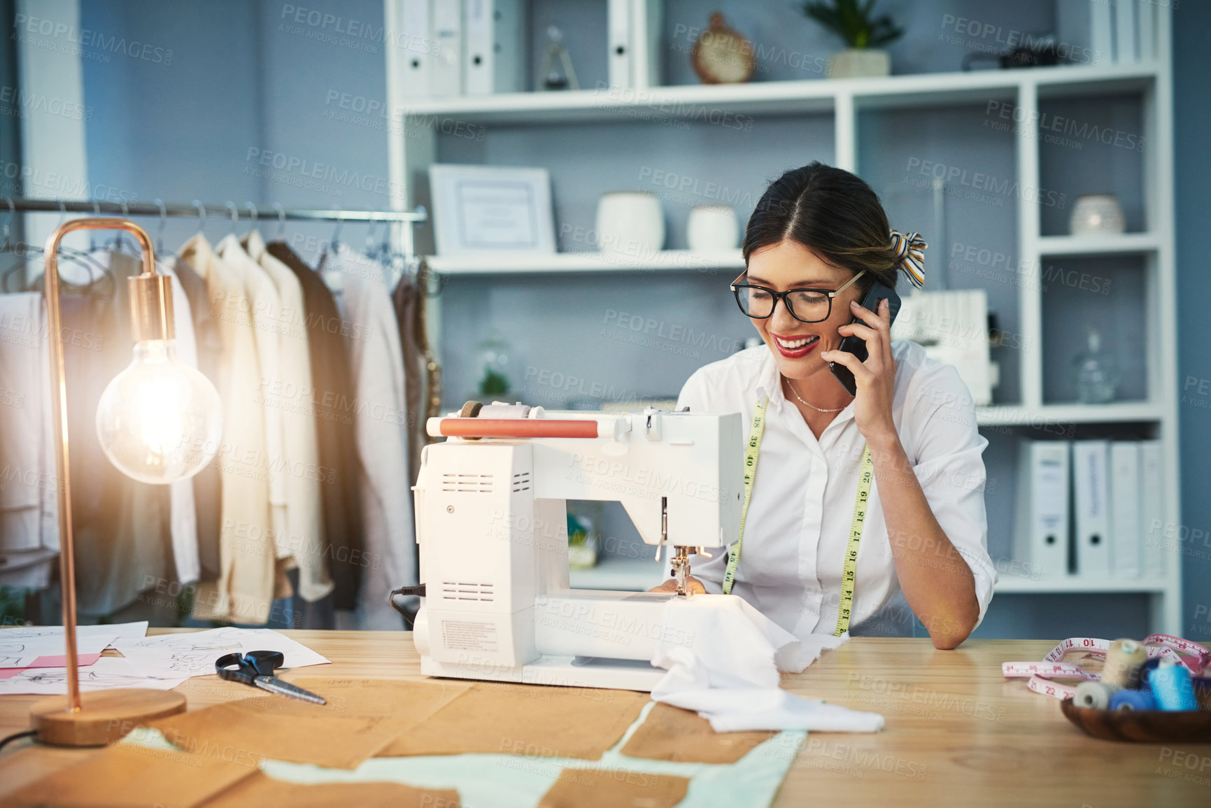 Buy stock photo Phone call, woman or designer for startup in fashion, clothes or textile business happy in sewing room for creative career. Design studio, workshop or tailor with smartphone for ecommerce in boutique