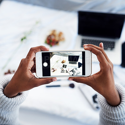 Buy stock photo High angle shot of an unrecognizable woman taking a photo of objects on her bed in her bedroom at home