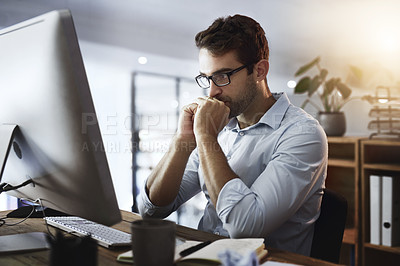 Buy stock photo Shot of a young businessman working late on a computer in an office