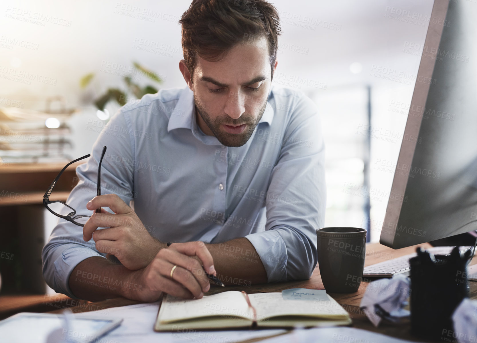 Buy stock photo Shot of a young businessman working late in an office