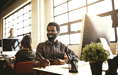 Buy stock photo Shot of a handsome businessman sitting at his desk in a modern office