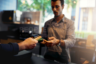 Buy stock photo Cropped shot of an unrecognizable male customer making credit card payment in a coffee shop