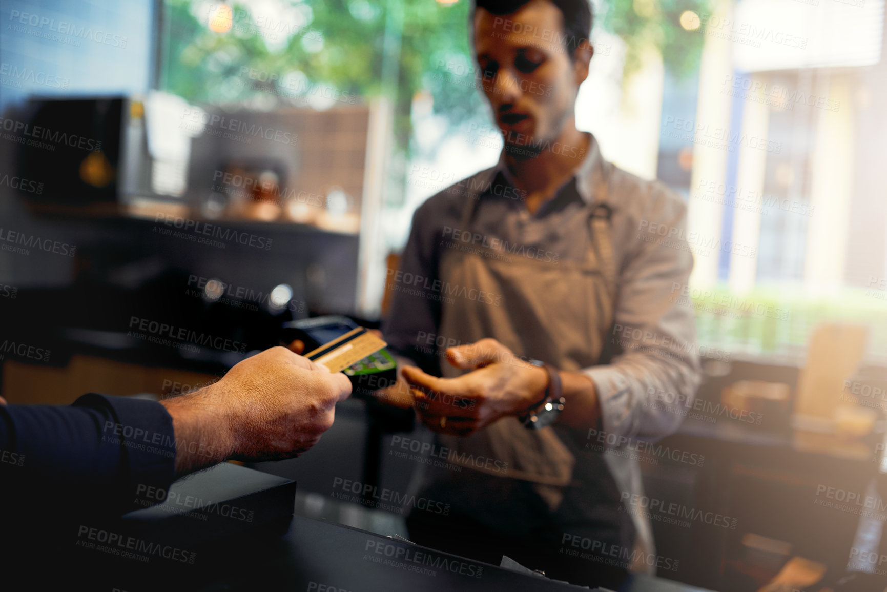 Buy stock photo Cropped shot of an unrecognizable male customer making credit card payment in a coffee shop