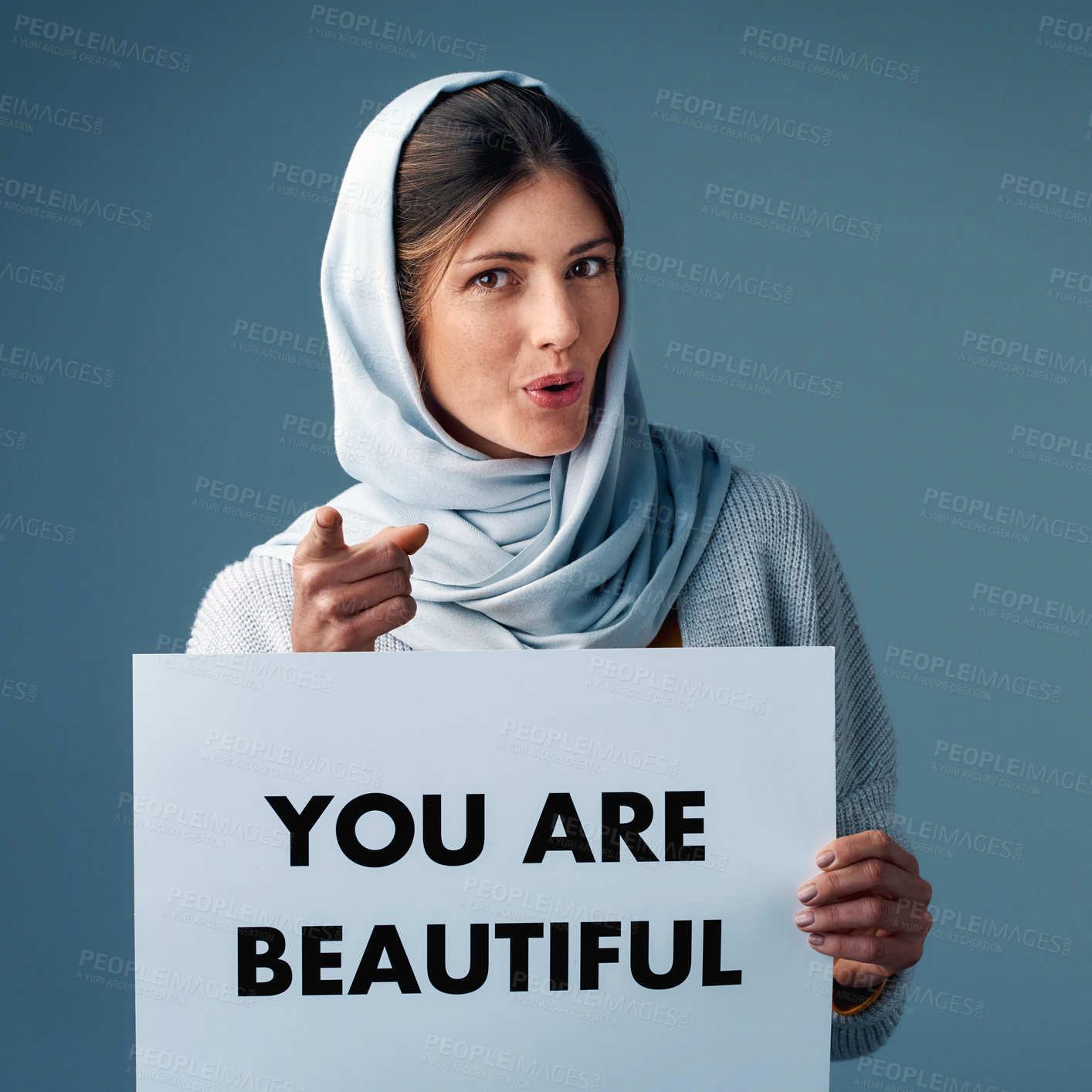 Buy stock photo Muslim, woman and pointing with poster in studio on blue background for equality, empowerment and activist. Female person, card and confident for human right campaign and advocate in portrait