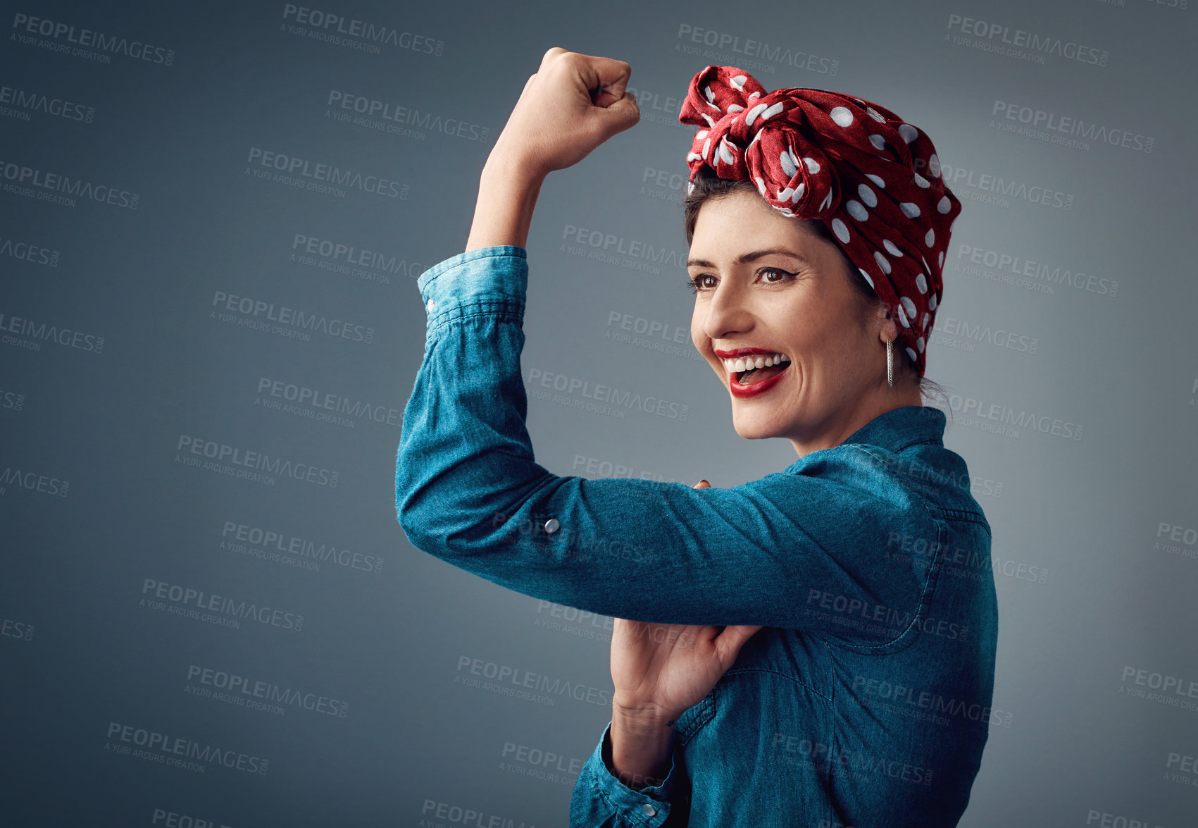 Buy stock photo Strong, flexing muscle and happy girl in studio for support, women power and pinup fashion. Female person thinking and laughing for bicep on grey background for motivation, freedom and vintage mockup