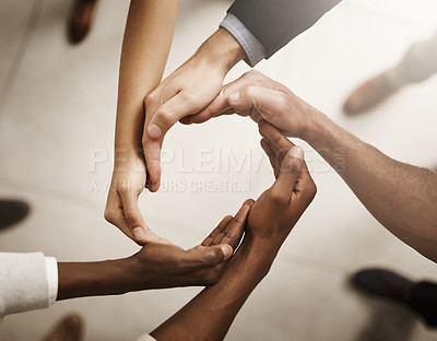 Buy stock photo Group of businesspeople joining their hands in solidarity in the workplace. Professional business people in unity for equality, diversity and success in a diverse teamwork.