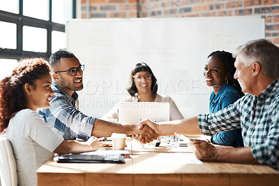 Buy stock photo Shot of two businessmen  shaking hands during a meeting in the boardroom