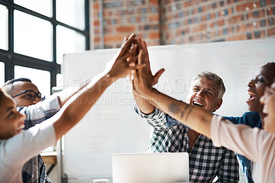 Buy stock photo Shot of a group of colleagues giving each other a high five during a boardroom meeting