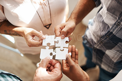Buy stock photo Cropped shot of a group of creatives connecting pieces of a puzzle